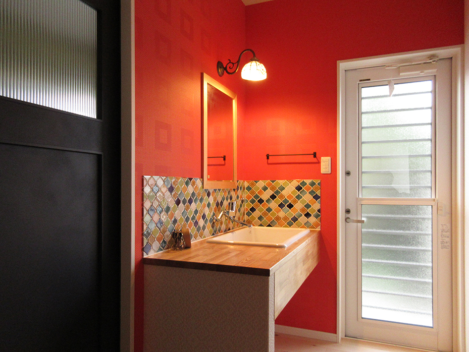 アンティーク風の照明やタイルで仕上げた洗面室。